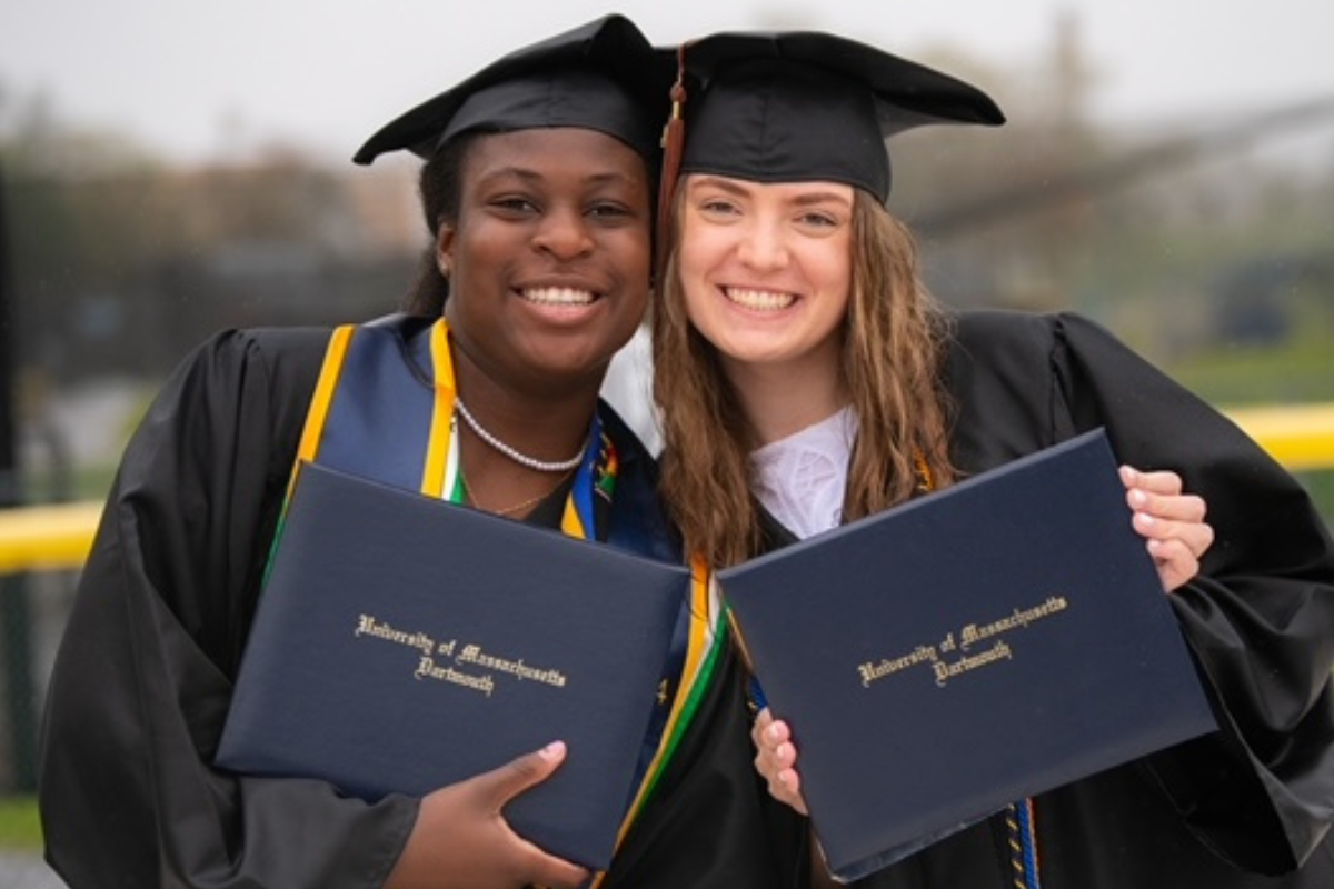 Students smile with diplomas