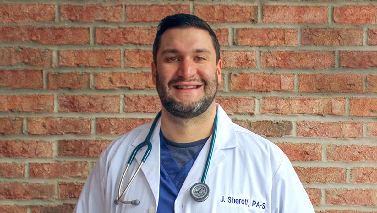 Jonathan Sheroff pictured in new lab coat and scrubs