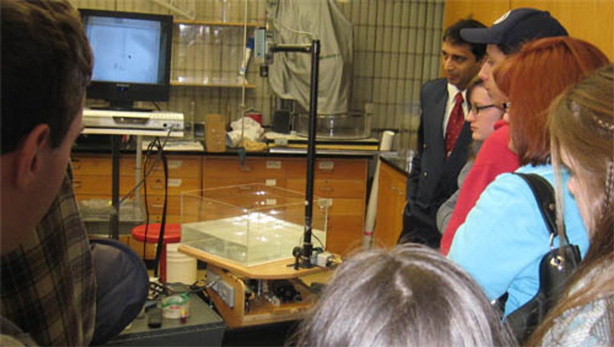 Students watching one of Amit Tandon's demonstrations using the rotating fluids table.