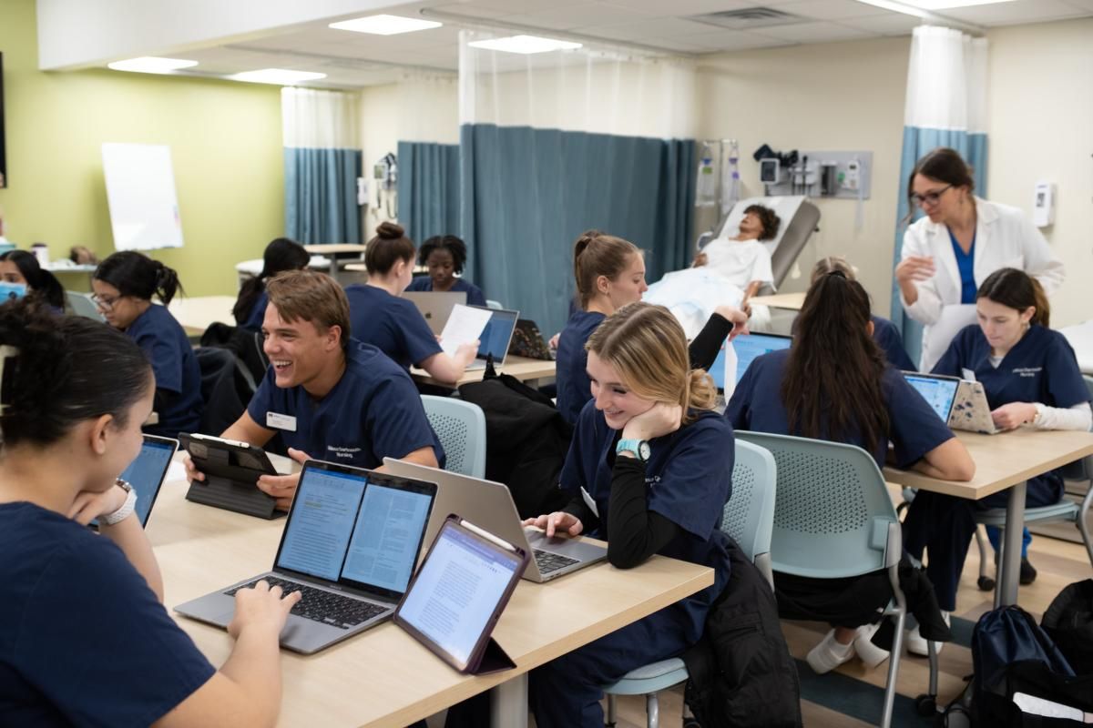 Students sitting in nursing lab with laptops