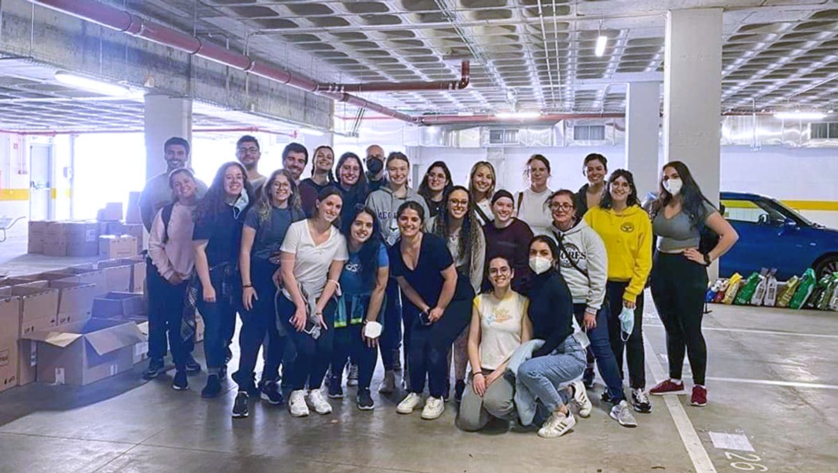 Students and faculty in warehouse packing supplies for Ukraine