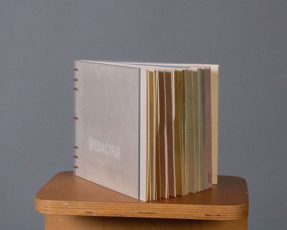 [REDACTED], 2022, Cover details for [REDACTED] – made from hand cut polycarbonate sheets sanded with steel wool around vinyl cut letters to create the title, 7x6 in