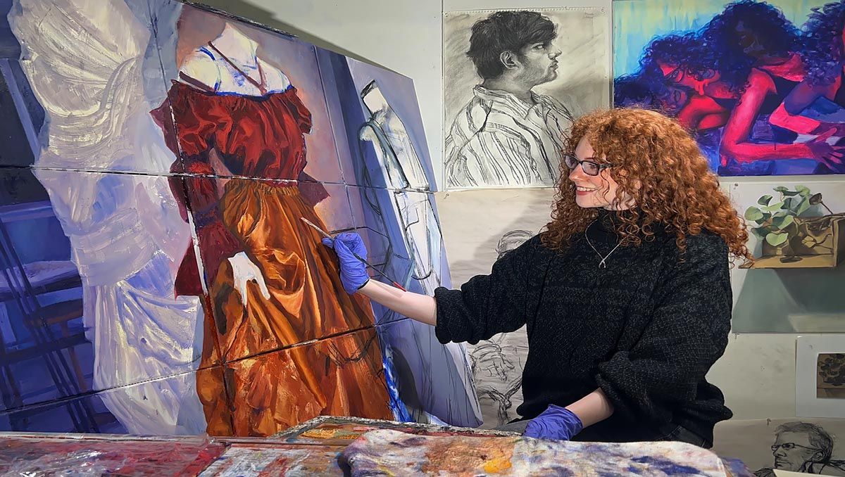 Amanda Driscoll painting at easel in studio