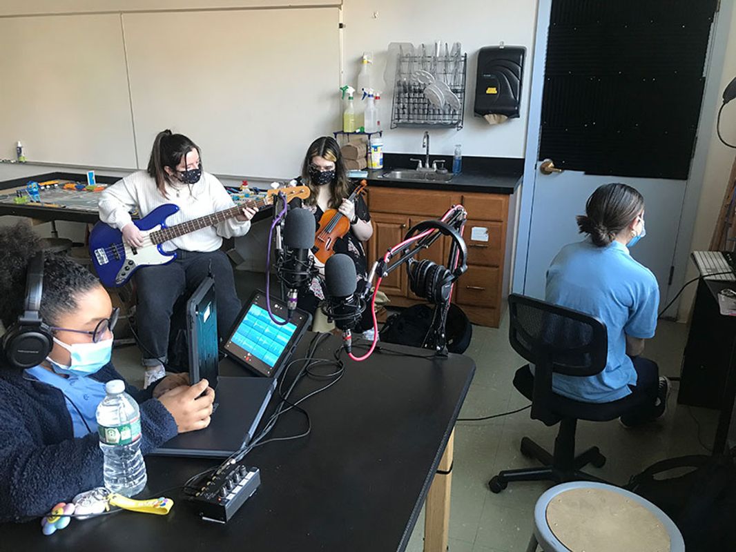 Katie (bass) and Vanessa (violin) are adding their instrumental expertise to a hip-hop song that the sound production class is creating.