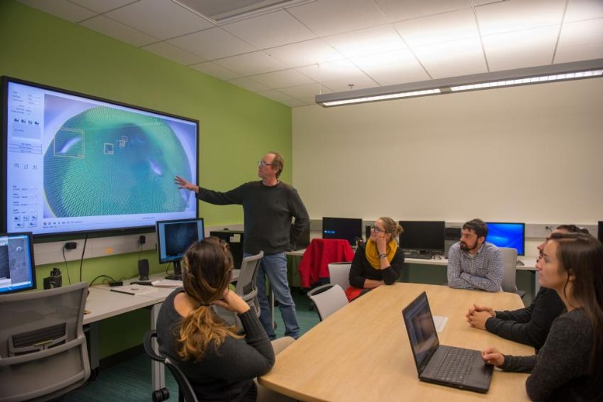 Prof. Stokesbury demonstrates the new SMAST East digitizing lab to students.