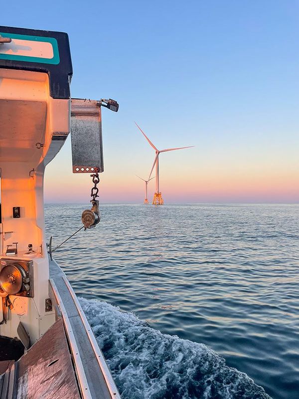 Block Island wing turbine at sunset from fishing boat