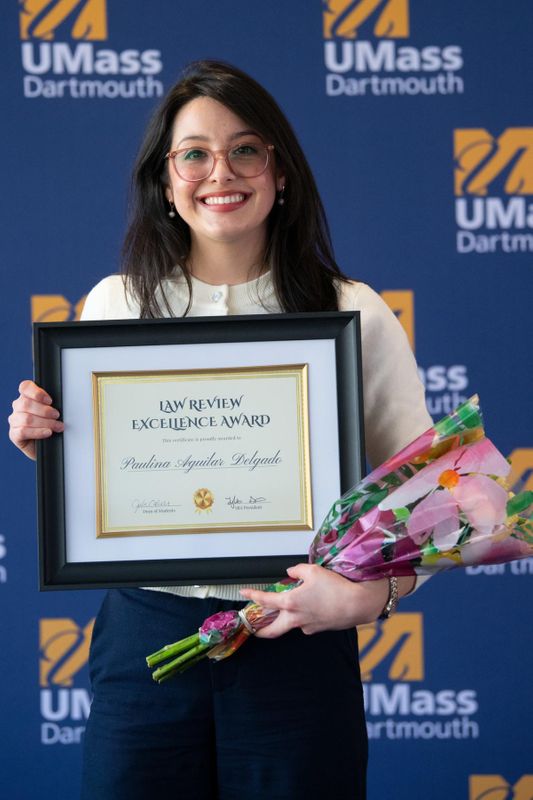 Aguilar Delgado pictured with the Law Review Excellence Award at the annual UMass Dartmouth Student Leadership Awards Ceremony.