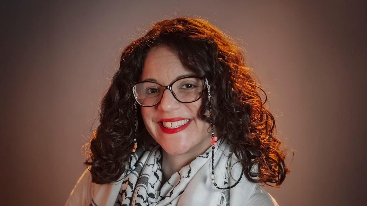 A headshot of Jessica Pabón '01 smiling in front of a brown background.