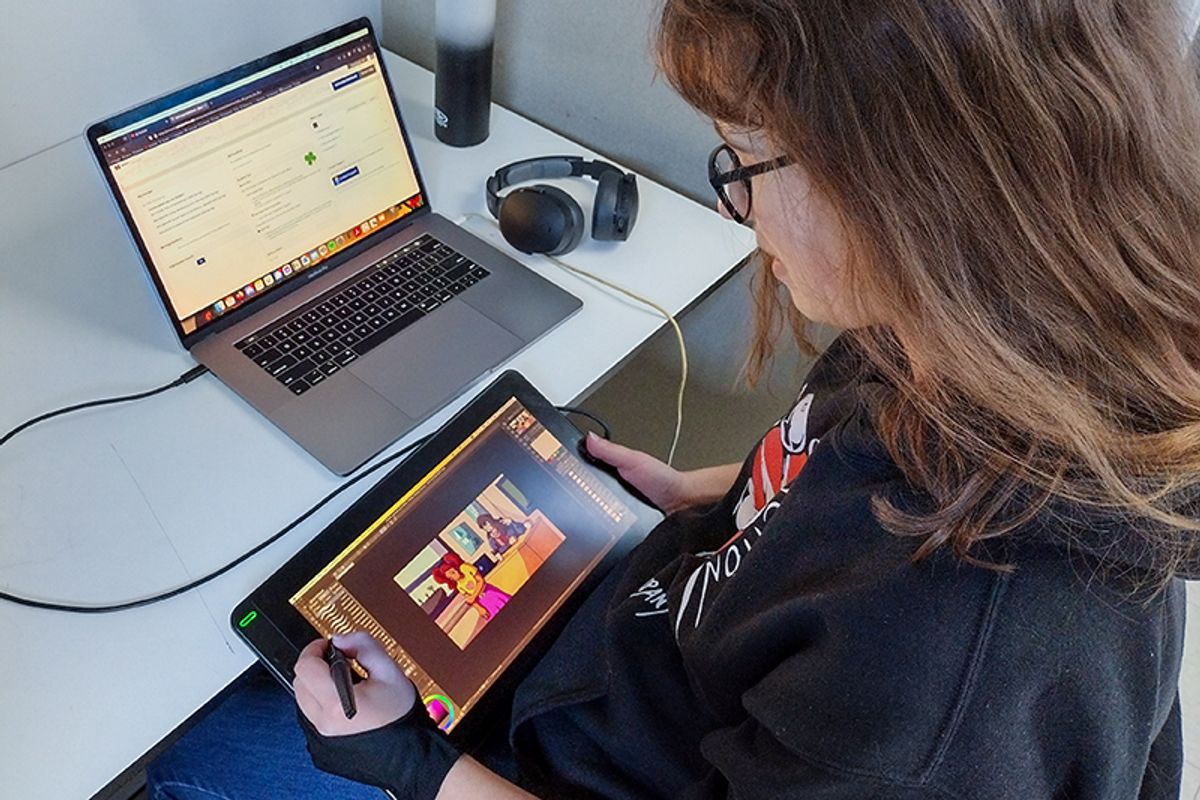 Student drawing on computer tablet