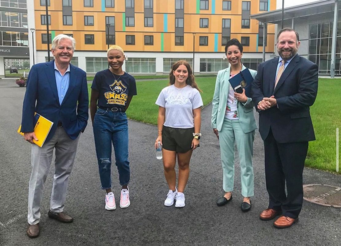 Students, admissions staff, and UMass President Marty Meehan standing outside new dorm