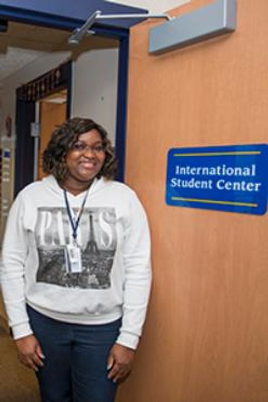 Oriane Pitah standing near International Student Center sign.