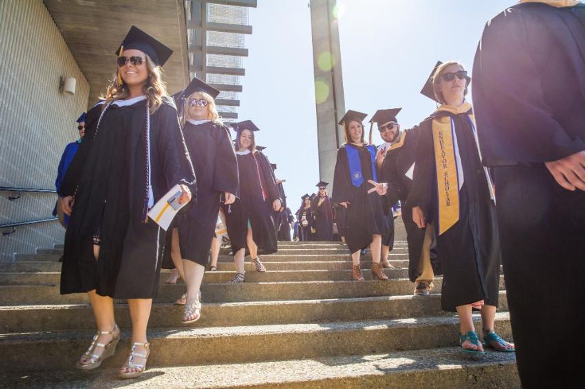 Students in regalia walking down the stairs