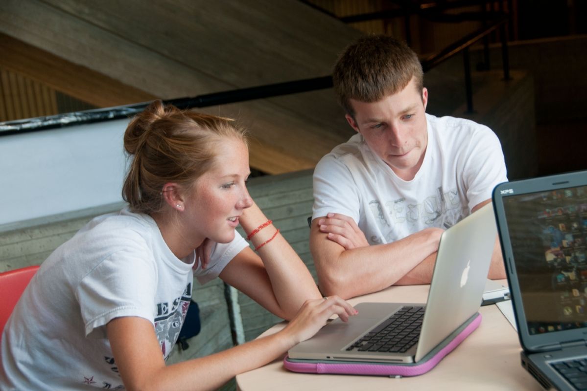Female and male students in front of computer