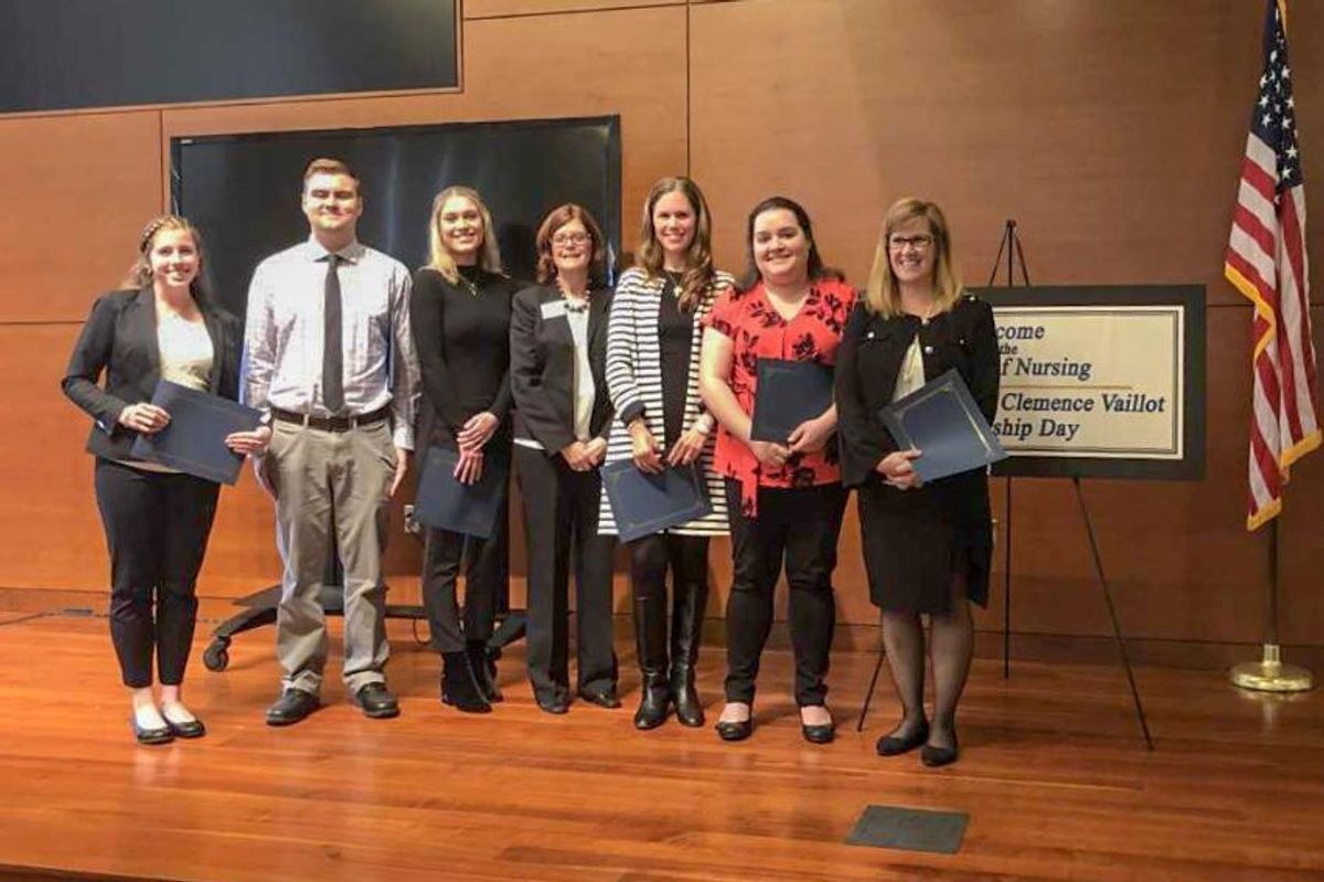 Undergraduate and graduate nursing poster contest winners with Dean Christopher