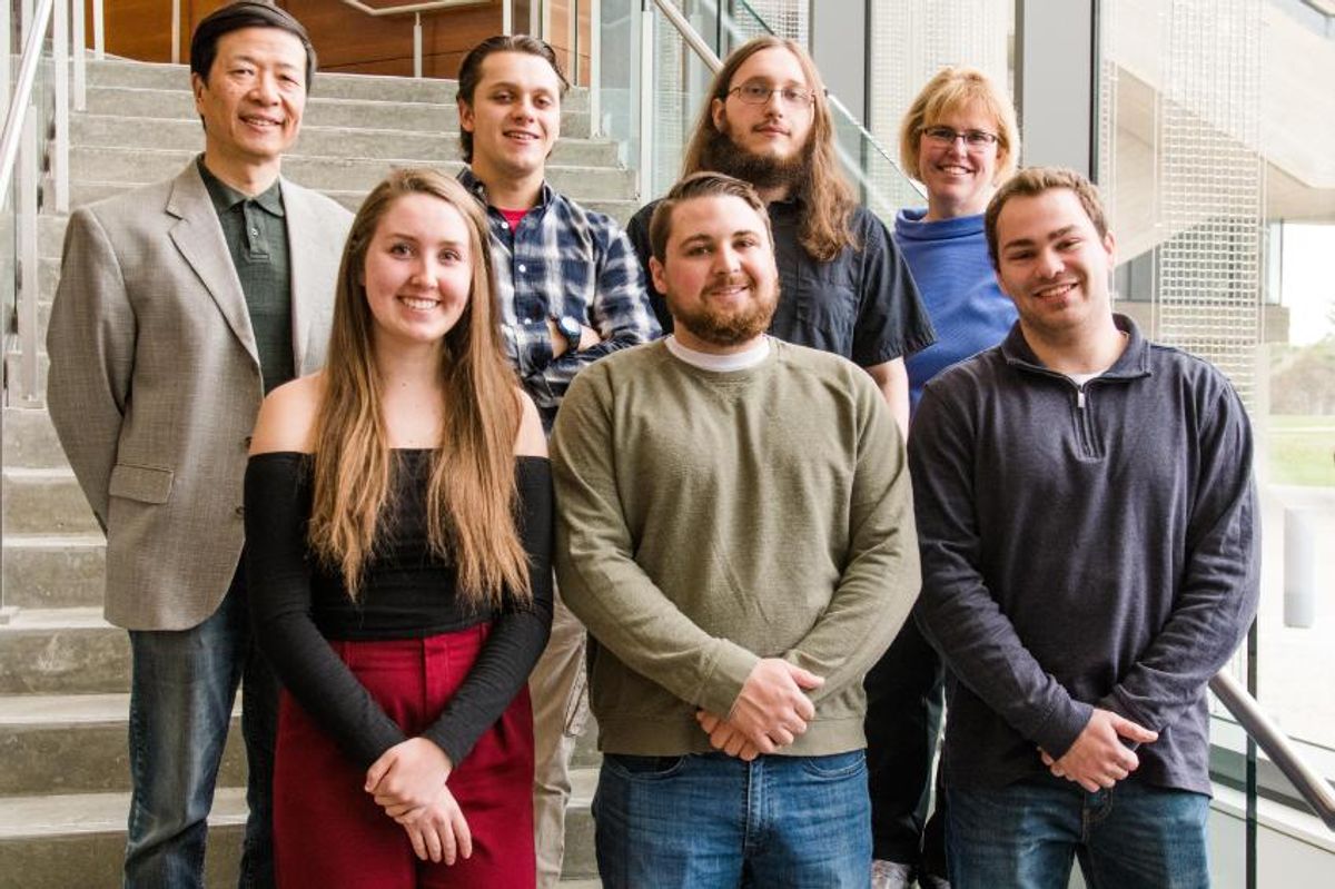 2nd place team from the Target Hackathon with five students and two faculty mentors standing on stairs in Claire T. Carney Library