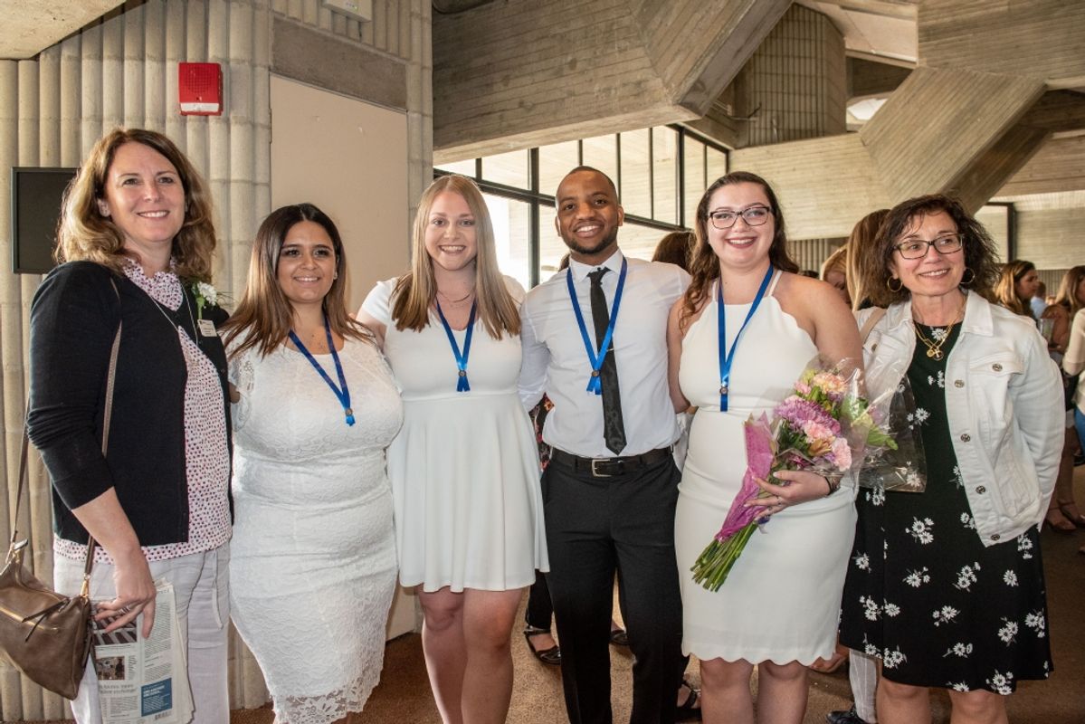 Assistant Professor Maryellen Brisbois standing with nursing students following pinning ceremony