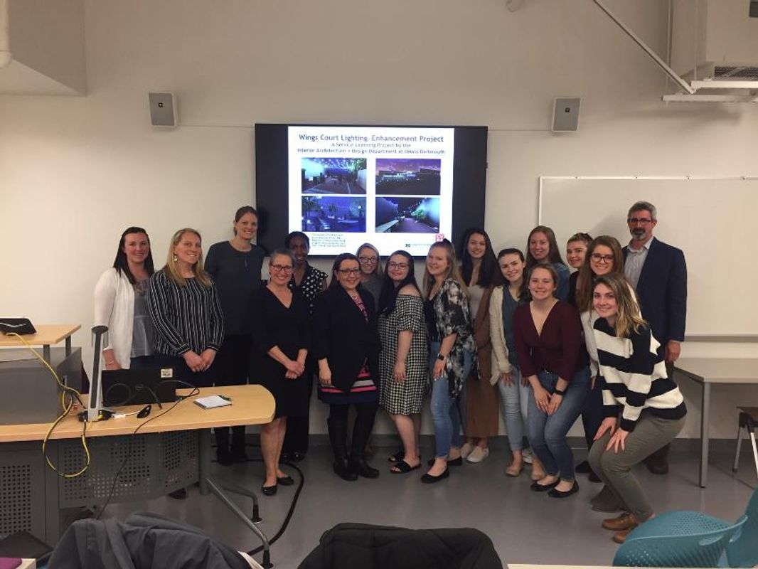 Design students posing in front of slideshow