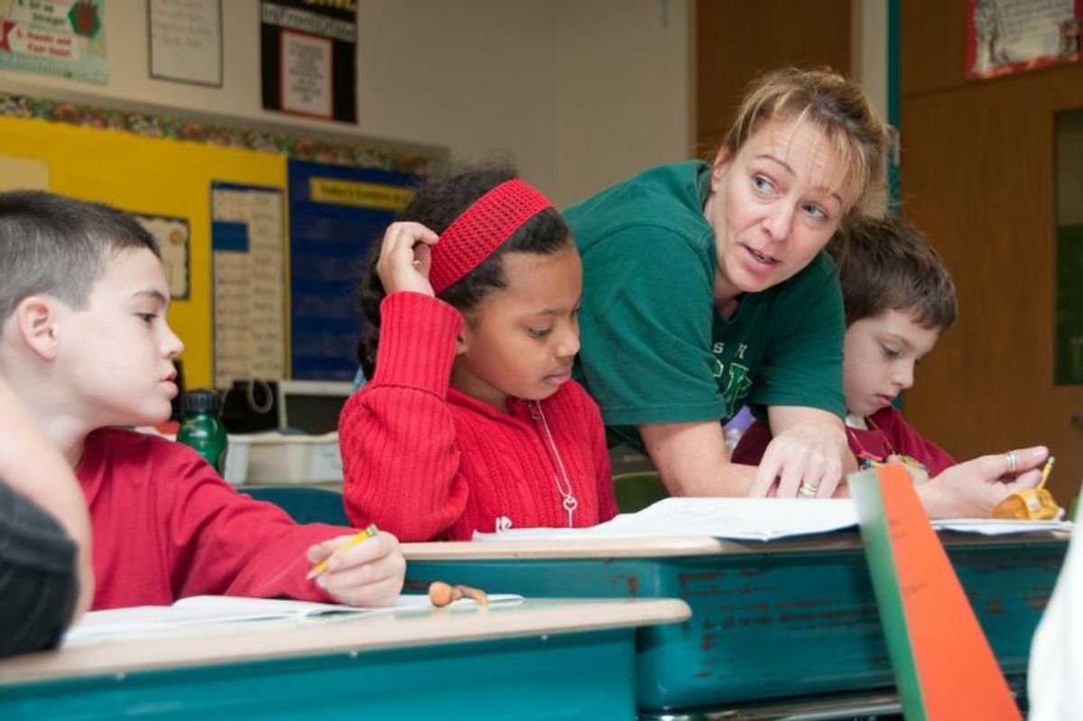 Teacher helping elementary students