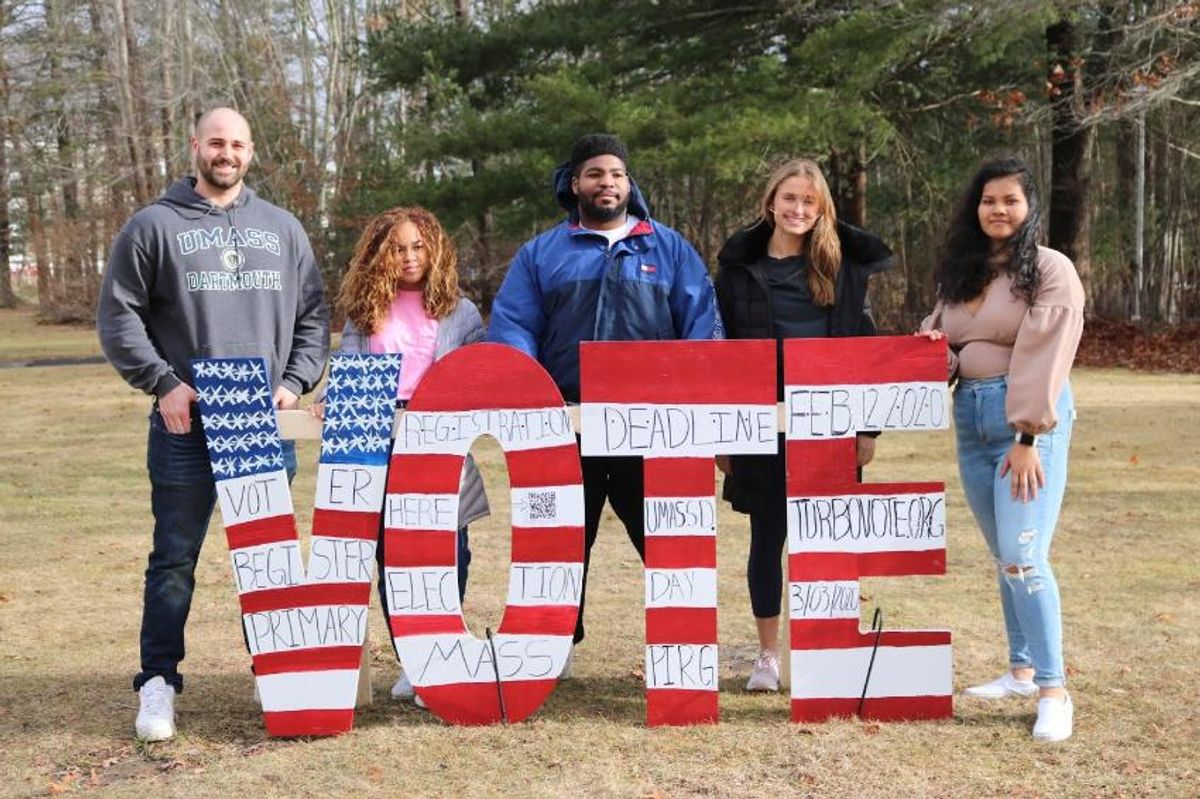 Student holding V-O-T-E signs
