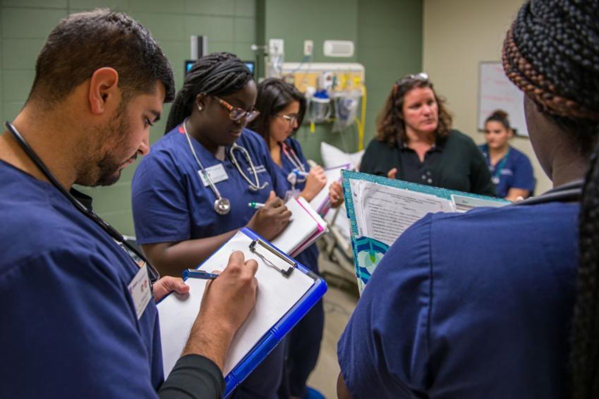  Nursing students in simulation lab taking notes
