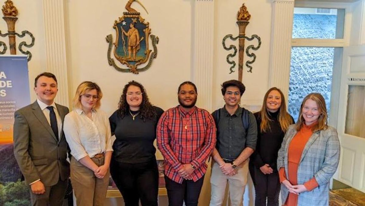 UMassD students Brad Ferris, Kelly Grodecki, Patrice Strague, Parker Sowersby, and Taha Bin Amer with [names] at [place] celebrating the launch of their app prototype.