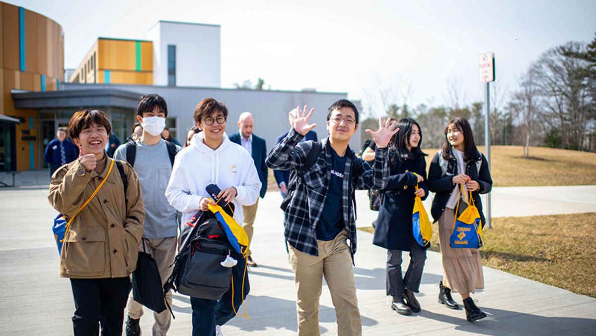 Japanese students exit the Grove sporting UMassD string bags en route to a campus tour by university administrators, and UMassD Model U.N. students.