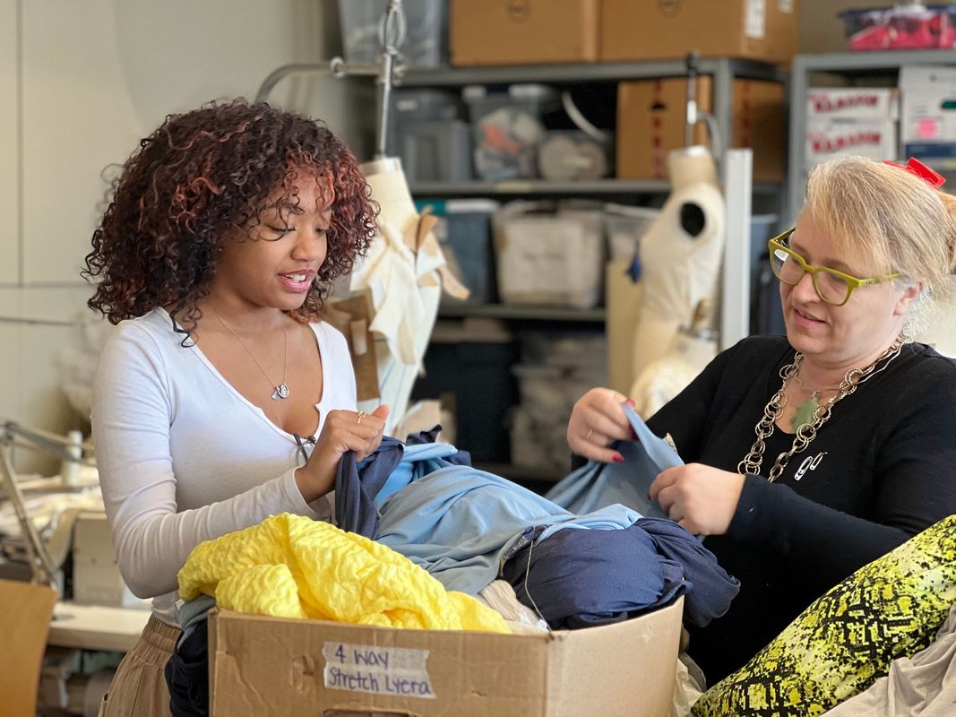 Brockton High student Kamilla Mathurin looking at fabric samples with UMass Dartmouth professor Aleta Deyo