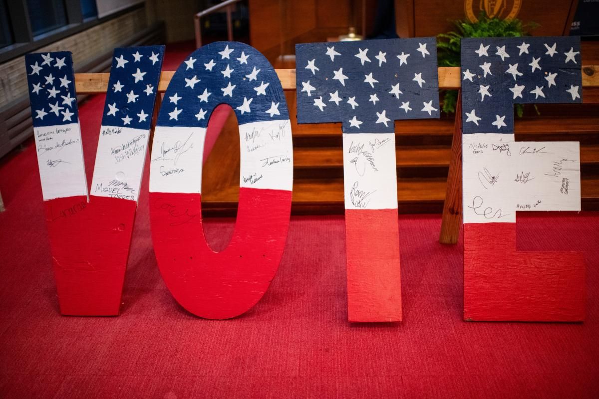 large wooden letters spelling V O T E