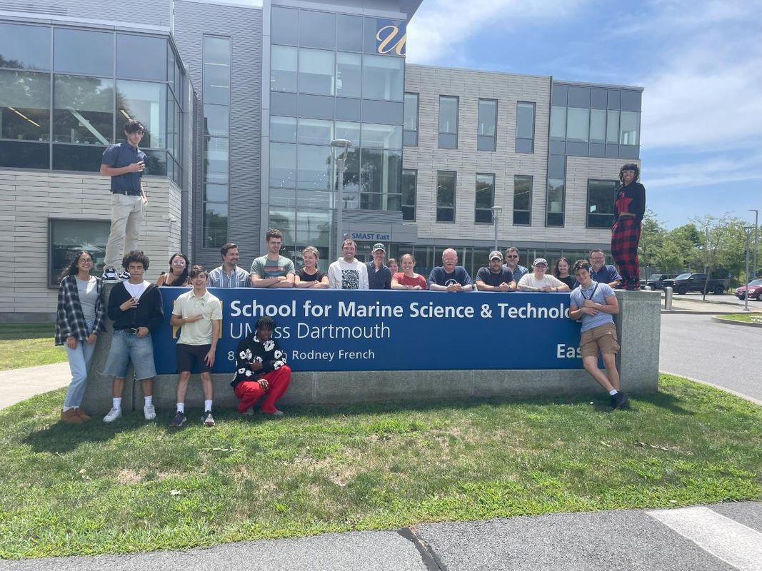 SMAST faculty and grad student supervisors with interns in front of the sign at SMAST East