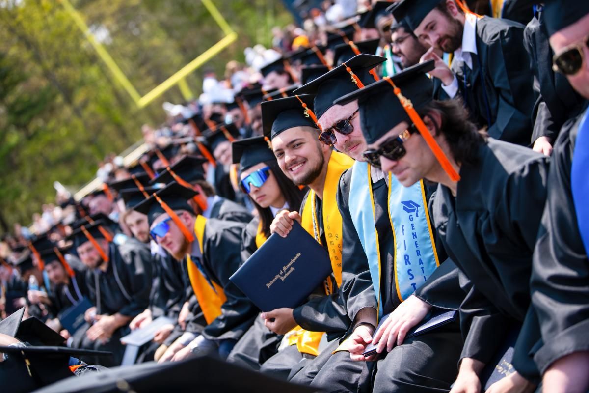 students in caps and gowns sitting at graduation