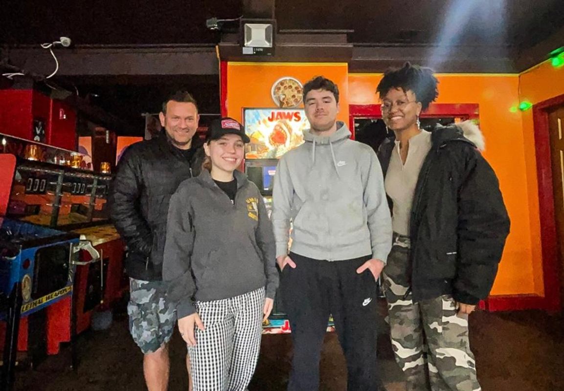 Left to Right: Adam Katz '97, owner of PLAY Arcade, and senior marketing majors Vanessa Pino, Kalvin Garcia, and Kristine Yancey