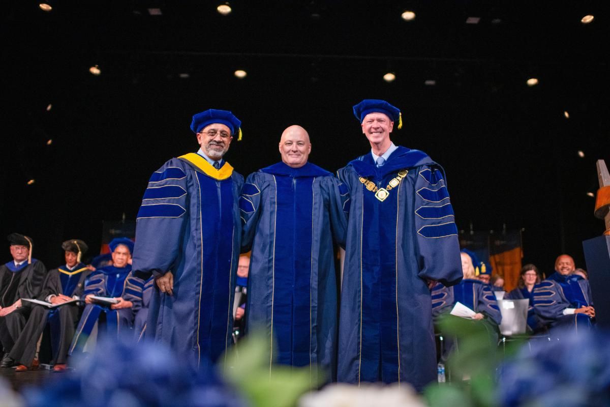 Provost, Scott Tingle, and Chancellor posing in commencement regalia