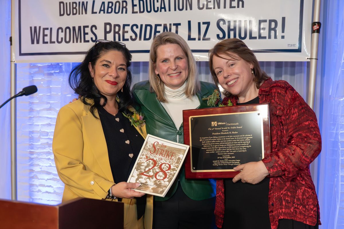 three women posed with award plaque