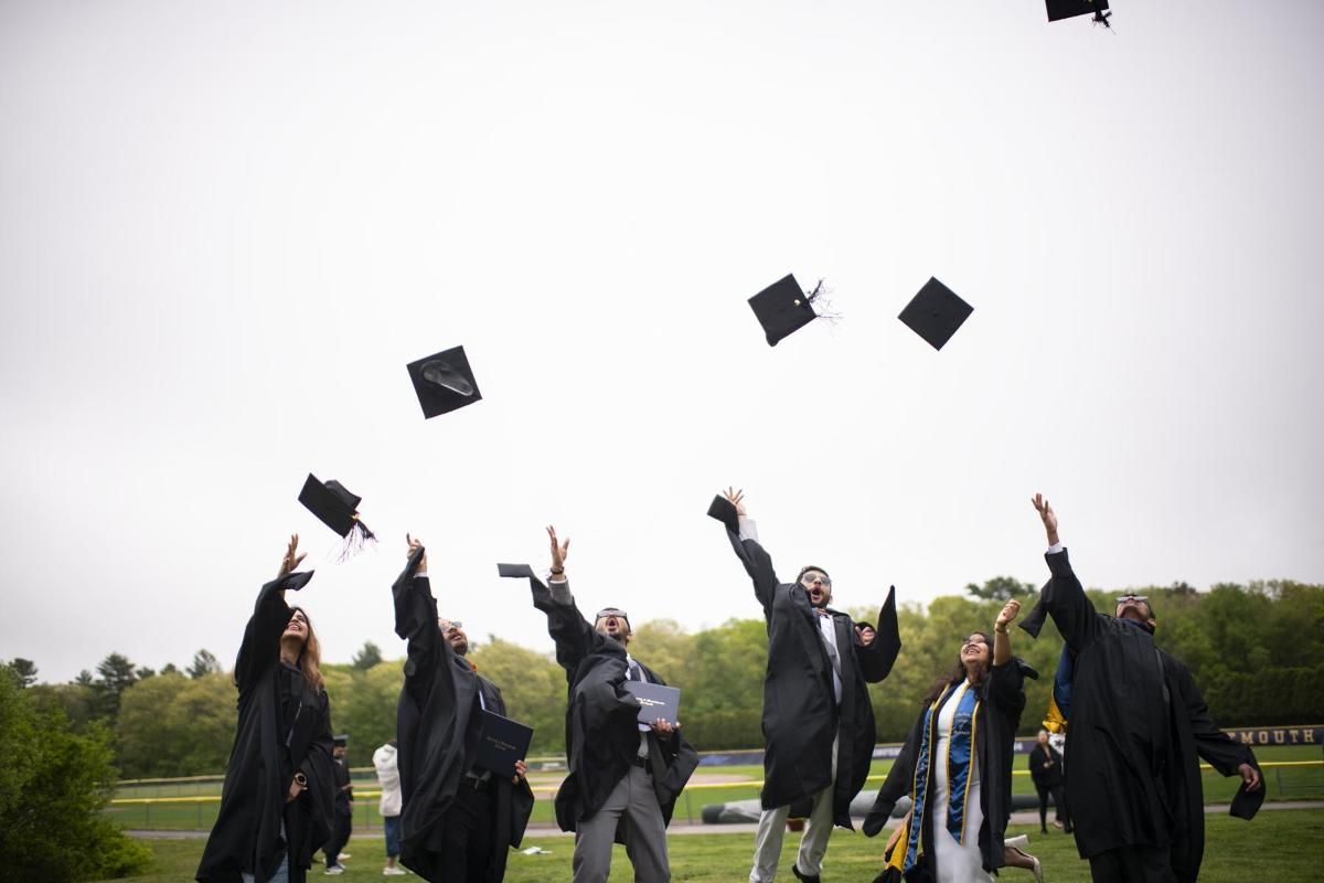 students throwing graduation caps in air