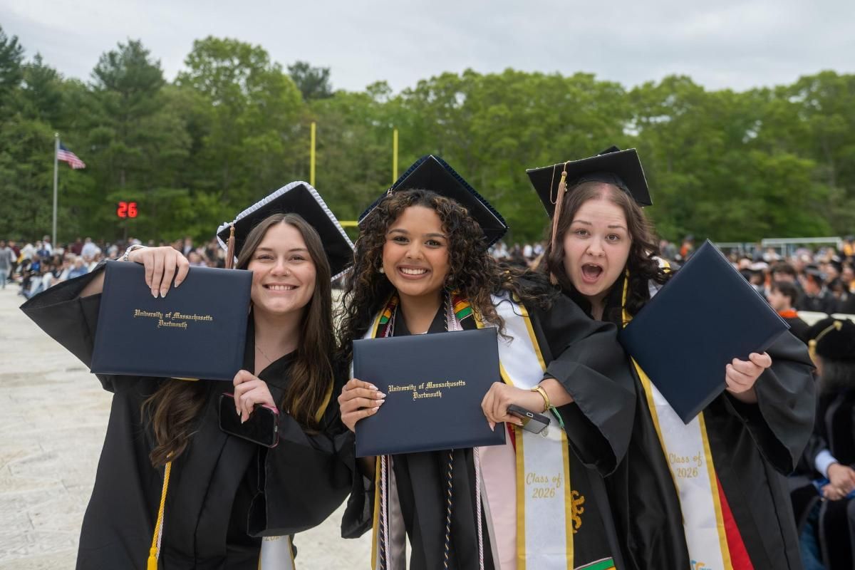 Students pictured with their diploma covers after crossing the stage at Commencement.