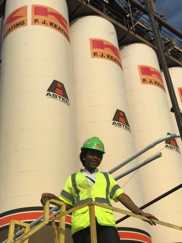 College of Engineering student Nneoma Ugwu '19 standing in front of large pipes at her internship at P.J. Keating in Acushnet.