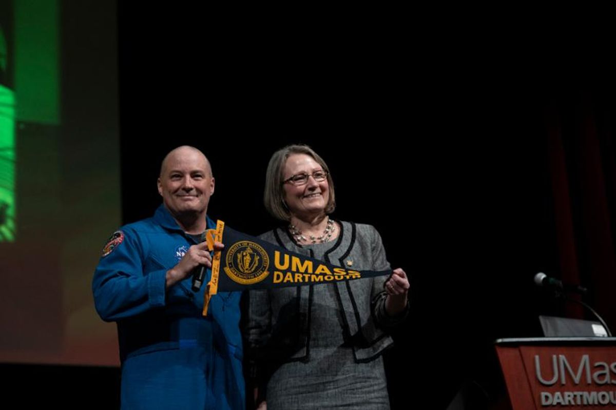 Astronaut Scott Tingle '87 presents a UMass Dartmout pennant to College of Engineering Dean Jean VanderGheynst