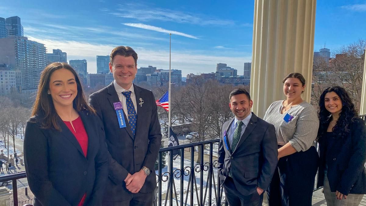 Walk the Hill captains pose on the Massachusetts State House balcony.