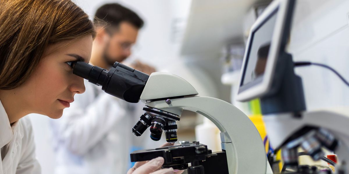 Student in a lab using microscope.