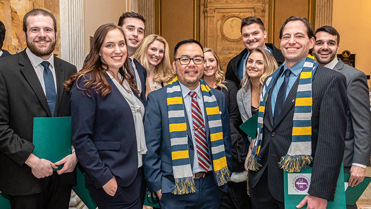 Professor at MA State House surrounded by law students at Walk to the Hill