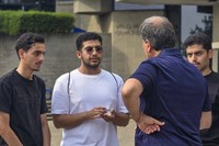 Saudi students speaking with faculty, on the quad