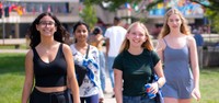 Students walking towards camera at an outdoor event at UMass Dartmouth.