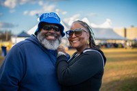 A smiling couple poses for a photo at the Blue & Gold Family Festival