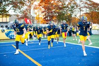 Corsair football players run onto the field at the start of a game during Blue & Gold Weekend