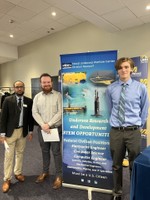 Student standing with representatives from the Naval Undersea Warfare Center
