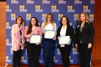 Nursing students posing with their awards along with nursing faculty