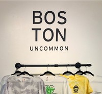 Vinyl Logo, 2022, wall logo installation above hanging rack, 21.5 x 21.25 in