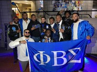 Fraternity brothers holding their banner proudly