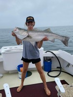 Graduate student Ali Frey with a striped bass	