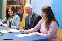 Molly Gedutis signing her certificate with Chancellor Fuller